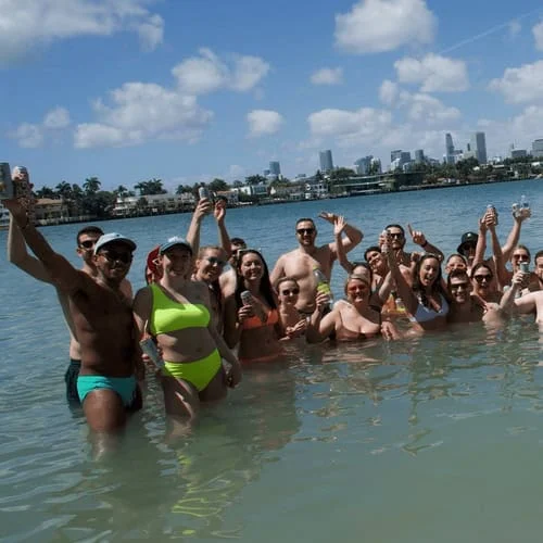 Group of people enjoying a day out in the ocean, posing for a photo with city skyline in the background. Group of people enjoying a day out in the ocean, posing for a photo with city skyline in the background.