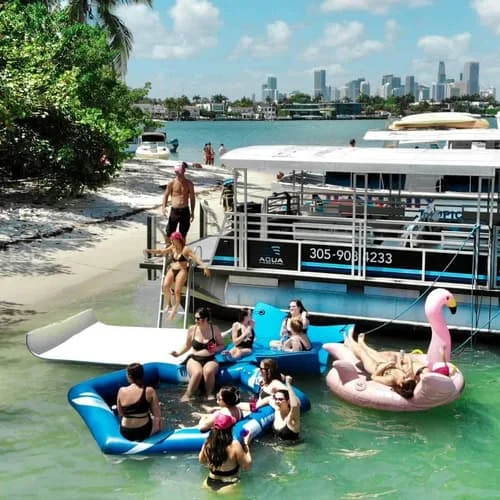 People enjoying a sunny day on a floating dock with inflatable rafts in the water near a city skyline. People enjoying a sunny day on a floating dock with inflatable rafts in the water near a city skyline.