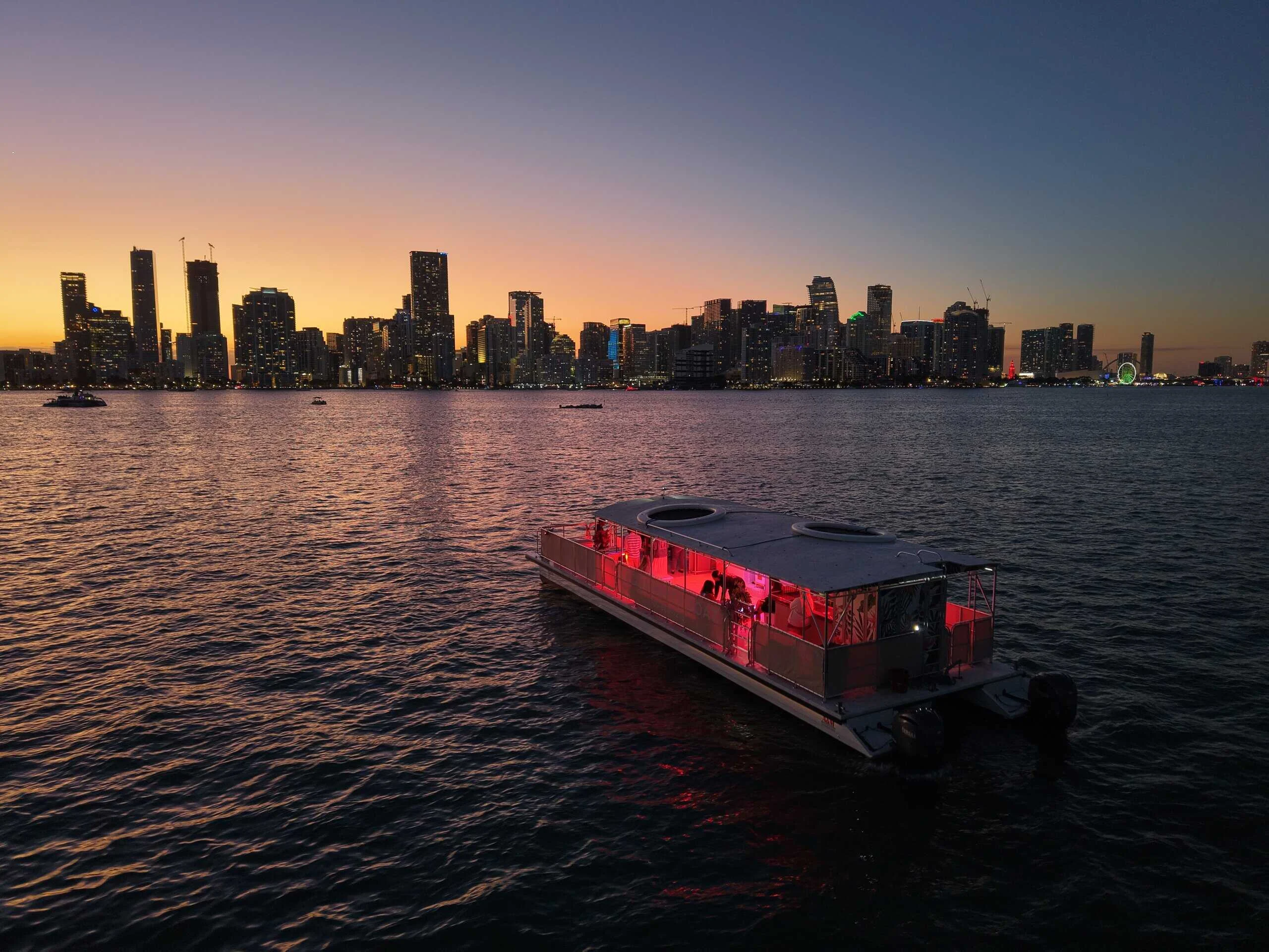 Private yacht charter for evening events in Miami: Guests enjoying a sunset tour with Aqua Party Boats and a floating mat